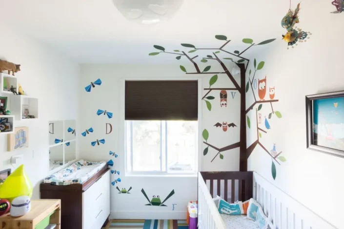 Gender neutral small nursery with tree and animal wall decals, perfect for small nurseries and neutral nursery design ideas.