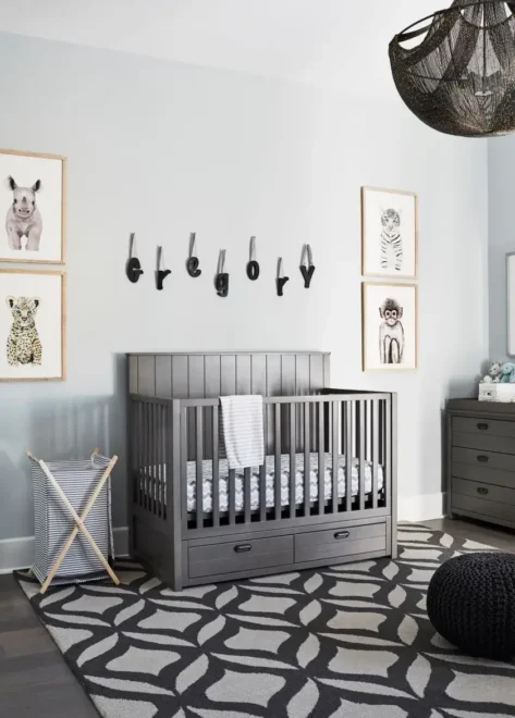 Gender-neutral nursery with gray crib, animal-themed wall prints, and striped blanket. Ideal for small nurseries and neutral nursery design