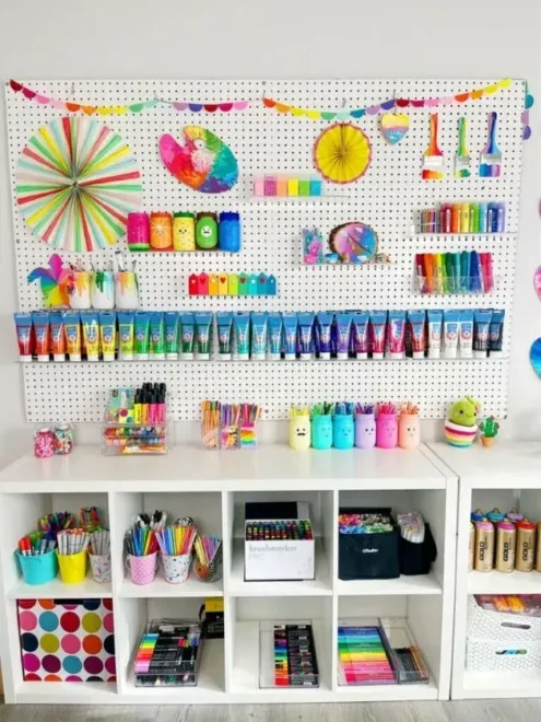 A tidy craft room featuring a pegboard wall and organized shelves with various art supplies.