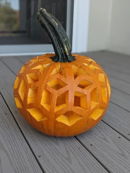 Pumpkin with intricate geometric carving featuring interlocking polygons and triangles, showcasing a unique and symmetrical design, perfect for easy but impressive Halloween decorations